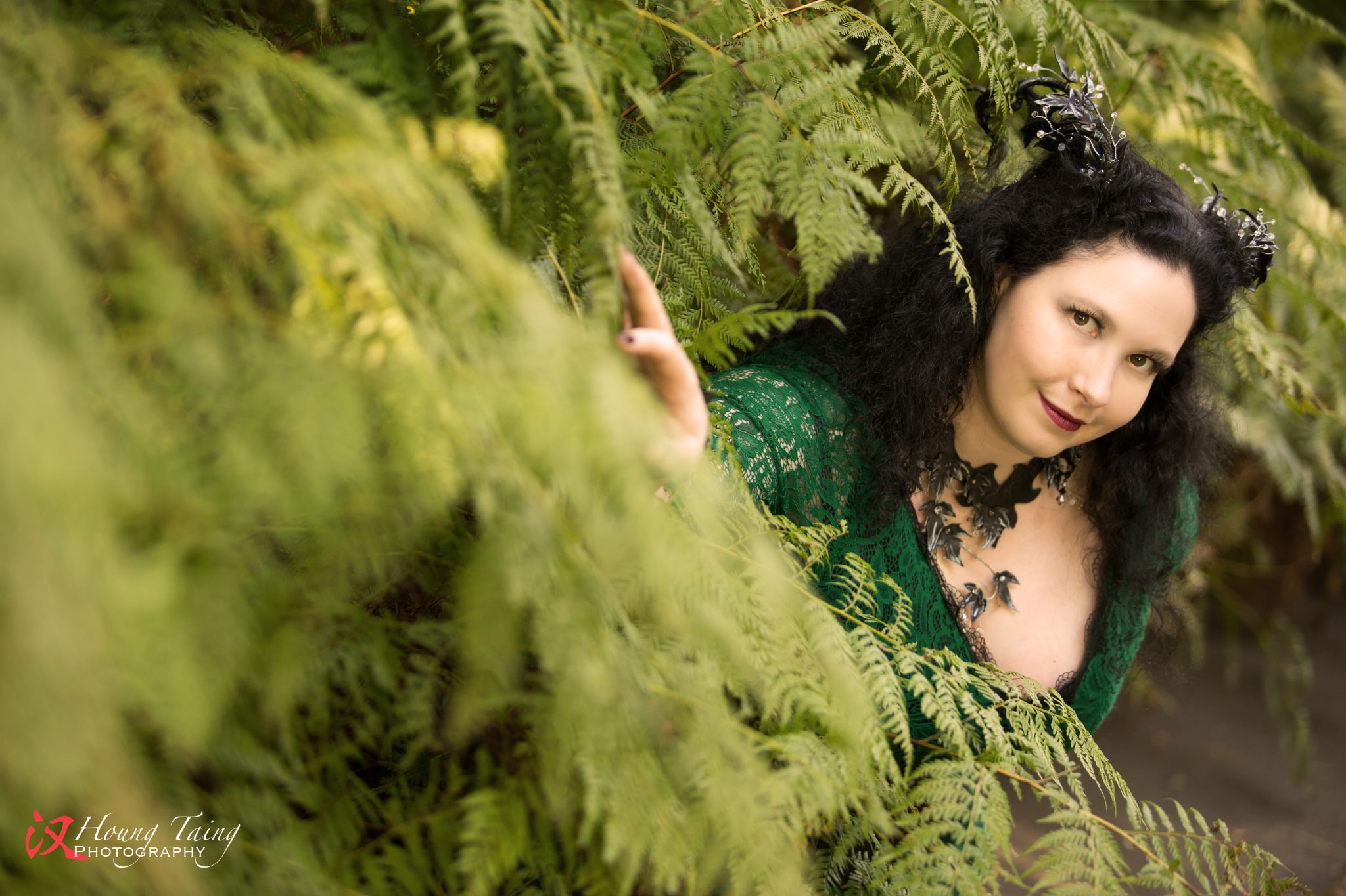 Melian, dark forest nymph, with a leafy green lace gown, black silk corset and black and silver leaves, crystals and horns.