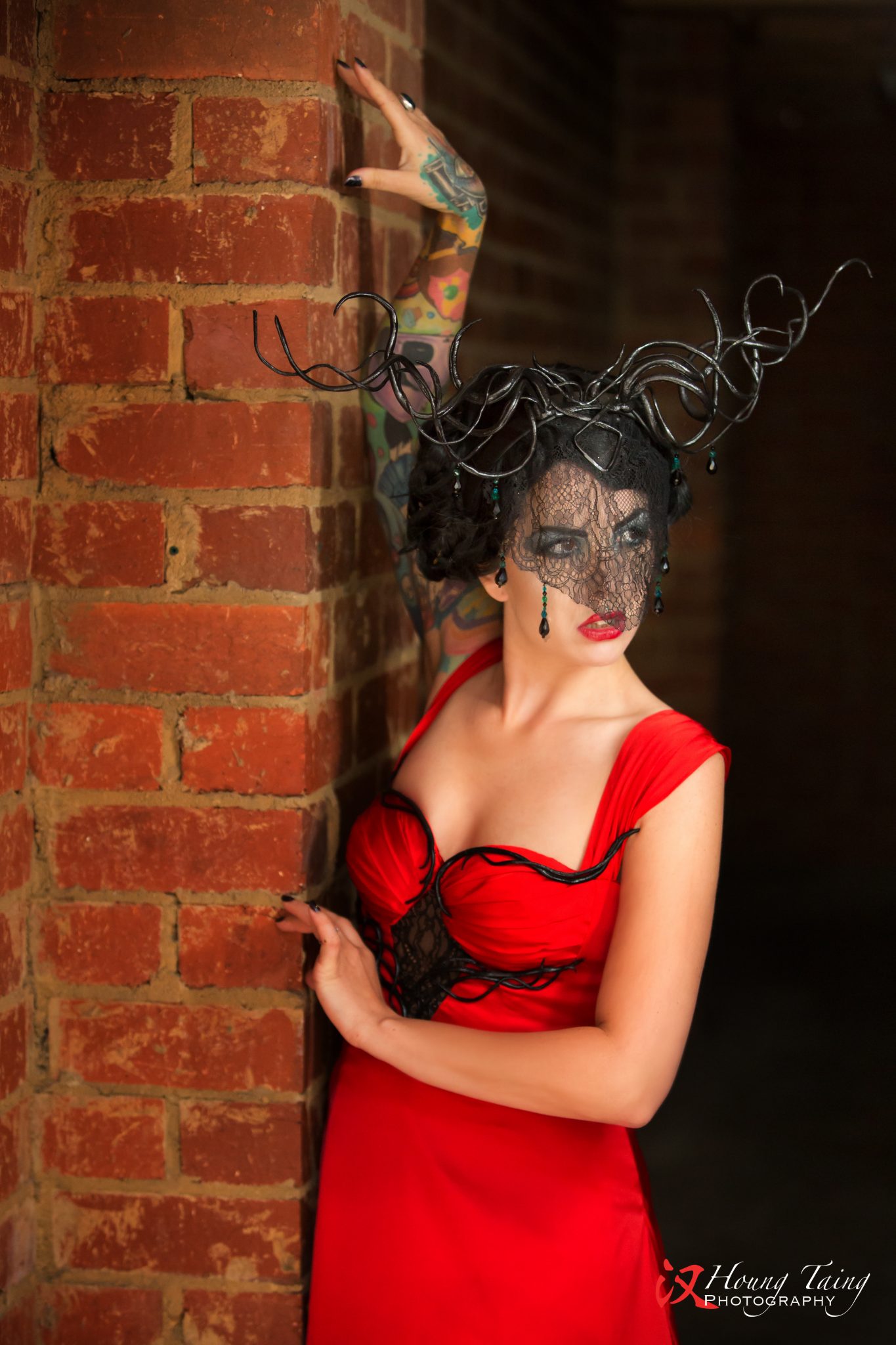 Arien, layered red gown, with twisted black horns with crytals and a black lace veil.